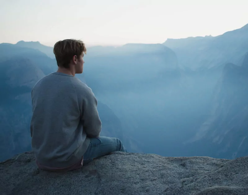 man meditating on mountain
